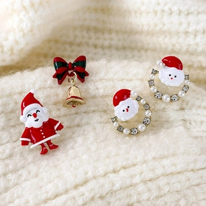 Asymmetric Christmas earrings featuring Santa Claus, pearl rings, and red bell bows