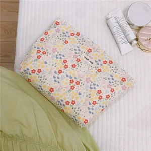 Detail of floral cotton makeup bag with colorful patterns on a soft quilted surface