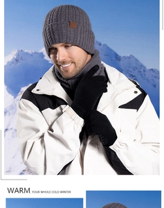 Close-up of winter knitted set featuring thick cable knit grey scarf and black gloves