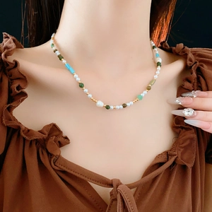 Close-up of elegant pearl and gemstone beaded necklace worn on a woman's neck