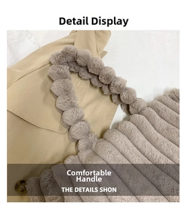 Detail of taupe plush striped handbag featuring a unique fuzzy pom-pom ball handle
