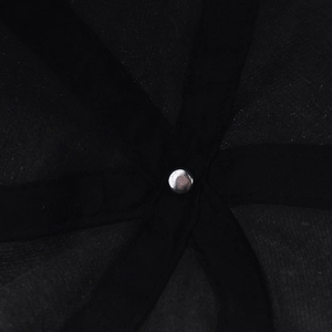 Détail macro des coutures renforcées et du rivet métallique argenté de la casquette noire