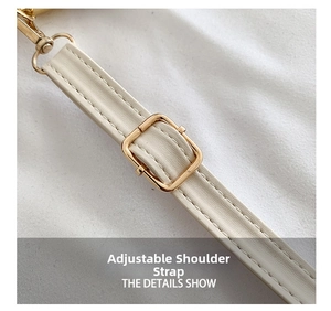 Close-up of adjustable strap with gold buckle on beige textured leather crossbody bag