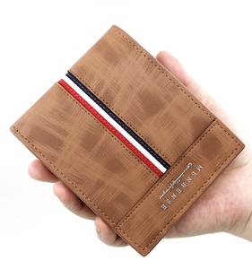 Brown frosted leather bifold wallet with signature tri-color stripe held by a hand