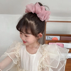 Close-up of a pink soft chiffon scrunchie worn on a ponytail for a sweet hair style