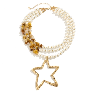 Close-up of multi-layer beaded necklace with turquoise and a large gold star pendant