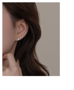 Close-up of elegant S999 sterling silver stud earring with sparkling round zircon on ear