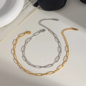 Detail of gold and silver paperclip chain anklets with lobster clasp and extender