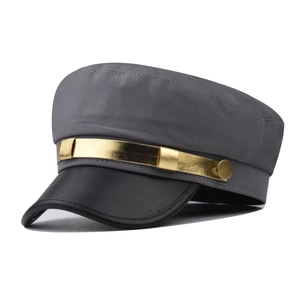 Détail d'une casquette gavroche grise avec visière en similicuir noir et chaîne dorée