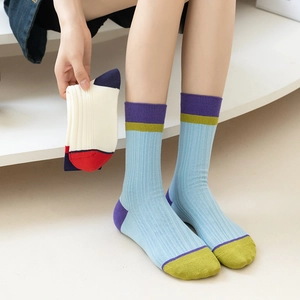 Detail of ribbed cotton crew socks with vibrant color block design and elastic texture