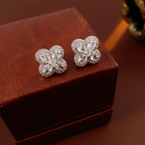 Gros plan sur les boucles d'oreilles trèfle à quatre feuilles avec zircons brillants