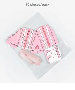 Flat lay of unassembled pink strawberry cake-shaped gift boxes with matching ribbons