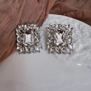 Vintage silver rectangle zircon earrings with emerald-cut crystals on ceramic plate