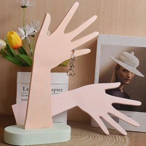 Dettaglio del supporto per gioielli a forma di mano in resina rosa con base ovale e cuore