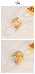 Detail showing 18K gold plated rings with wavy textures and hammered honeycomb patterns