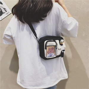 Detail of canvas crossbody bag with clear card slot and colorful rainbow patch
