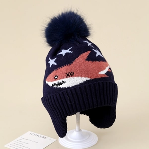 Close-up of navy knit hat showing soft pom-pom detail and shark jacquard pattern
