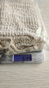 Detail of natural jute soap pouch on a digital scale showing net weight and woven texture