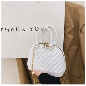 Close-up of white shell jelly bag with V-shaped wave texture and gold chain strap
