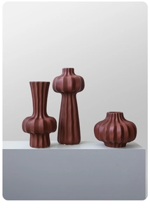 Close-up of three ribbed terracotta ceramic vases with minimalist matte finish