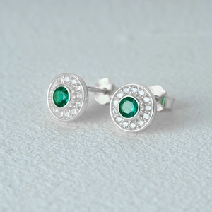 Macro shot of S925 silver round earrings featuring a green stone and white diamonds