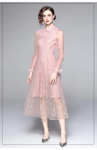Gros plan d'une robe en dentelle rose avec broderies et col montant élégant