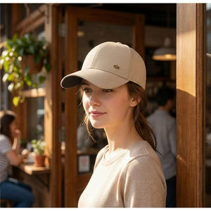 Close-up of beige cotton baseball cap featuring a small metallic 'alo' side logo detail