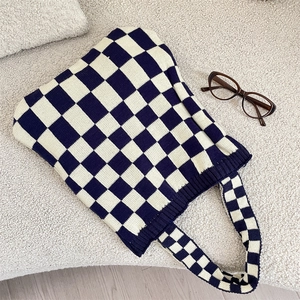 Macro detail of navy and cream checkered knit fabric texture and ribbed edge craftsmanship