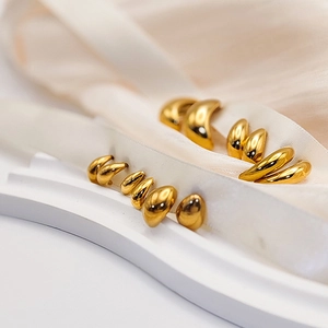 Macro shot of 18K gold plated teardrop earrings with high-polish metallic texture