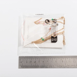 Detail view of multi-layer colorful beaded necklace in packaging with measurement scale