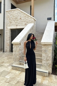 Detail of elegant black halter dress featuring chest cut-out and waist ruching design