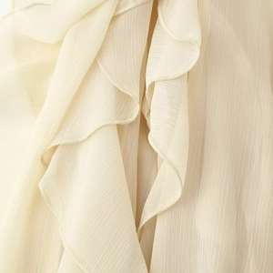 Élégante blouse en mousseline blanc crème avec volants superposés et col en V délicat
