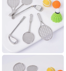 Detailed macro view of miniature metal tennis racket and golf club model keychains