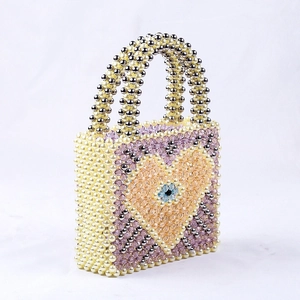 Handmade beaded handbag with heart and evil eye motif on ivory and silver pearls