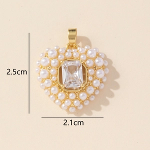 Detailed view of a gold heart pendant with crystal center and double pearl border