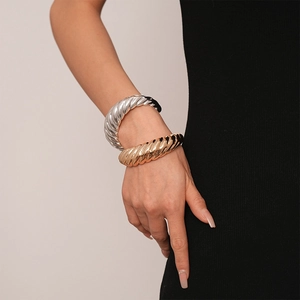 Bracelets ouverts en métal à rayures irrégulières dorés et argentés sur poignet