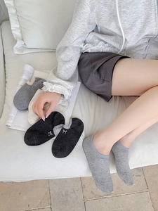 Close-up of low-cut invisible boat socks with delicate butterfly bow embroidery