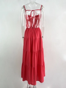 Detail of coral red tiered maxi dress with thin straps and open back design