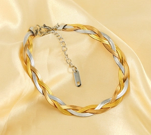 Detailed macro of a tri-color braided flat snake chain bracelet with lobster clasp