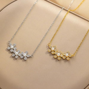 Close-up of gold and silver flower pendants with zircons and pearls on leather background
