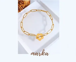 Detail of gold floral toggle clasp on minimalist chunky chain bracelet with dried roses