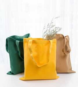 Close-up of colorful cotton canvas drawstring bags in green, yellow, and khaki finish