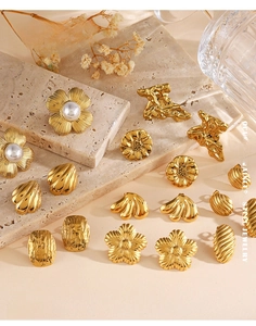 Detailed view of various vintage gold stainless steel earrings with floral and geometric motifs