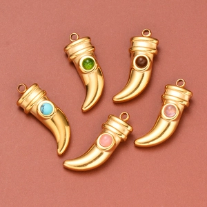 Macro view of five colorful horn pendants with inset gemstones on brown background