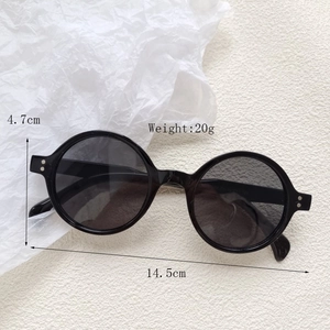 Flat lay of round black sunglasses with dimension measurements of 14.5cm width and 4.7cm height