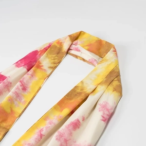 Vista dettagliata del tessuto tie-dye con motivi gialli, rosa e arancioni ad alta risoluzione