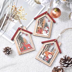 Trois ornements maison en bois avec Père Noël, bonhomme de neige et renne sur fond en peluche