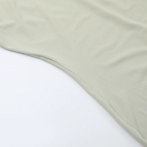 Close-up of light green knit fabric showing fine stitching and soft texture detail