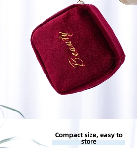Detail of burgundy velvet mini lipstick pouch with gold Beauty embroidery and gold zipper