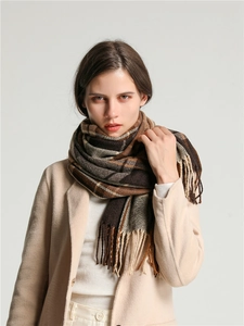 Detail shot of brown plaid scarf fringe and textured thick wool-like winter fabric